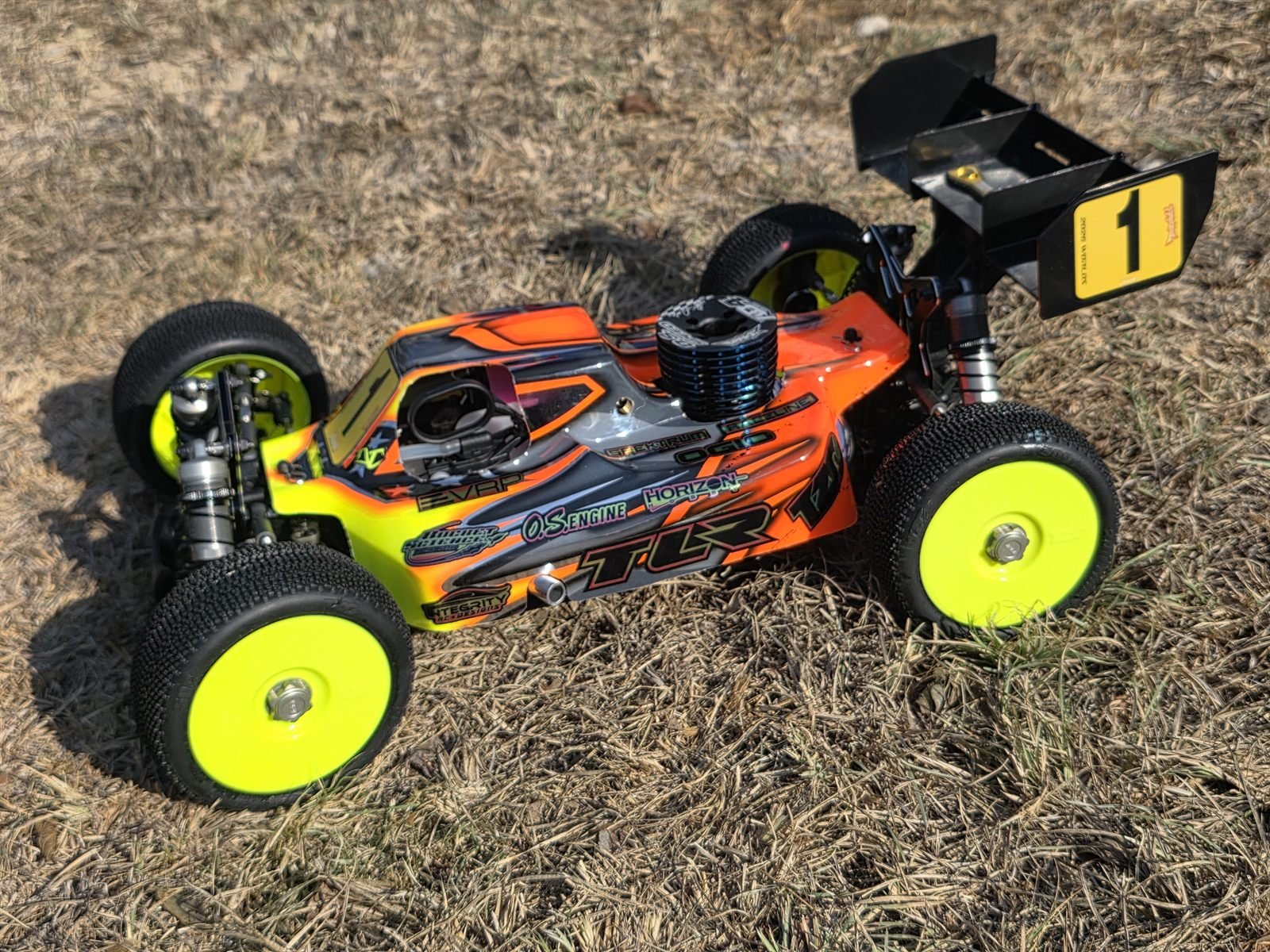 A 1/8 nitro buggy wearing an Integrity RC Designs custom wrap and a number 1 plate.