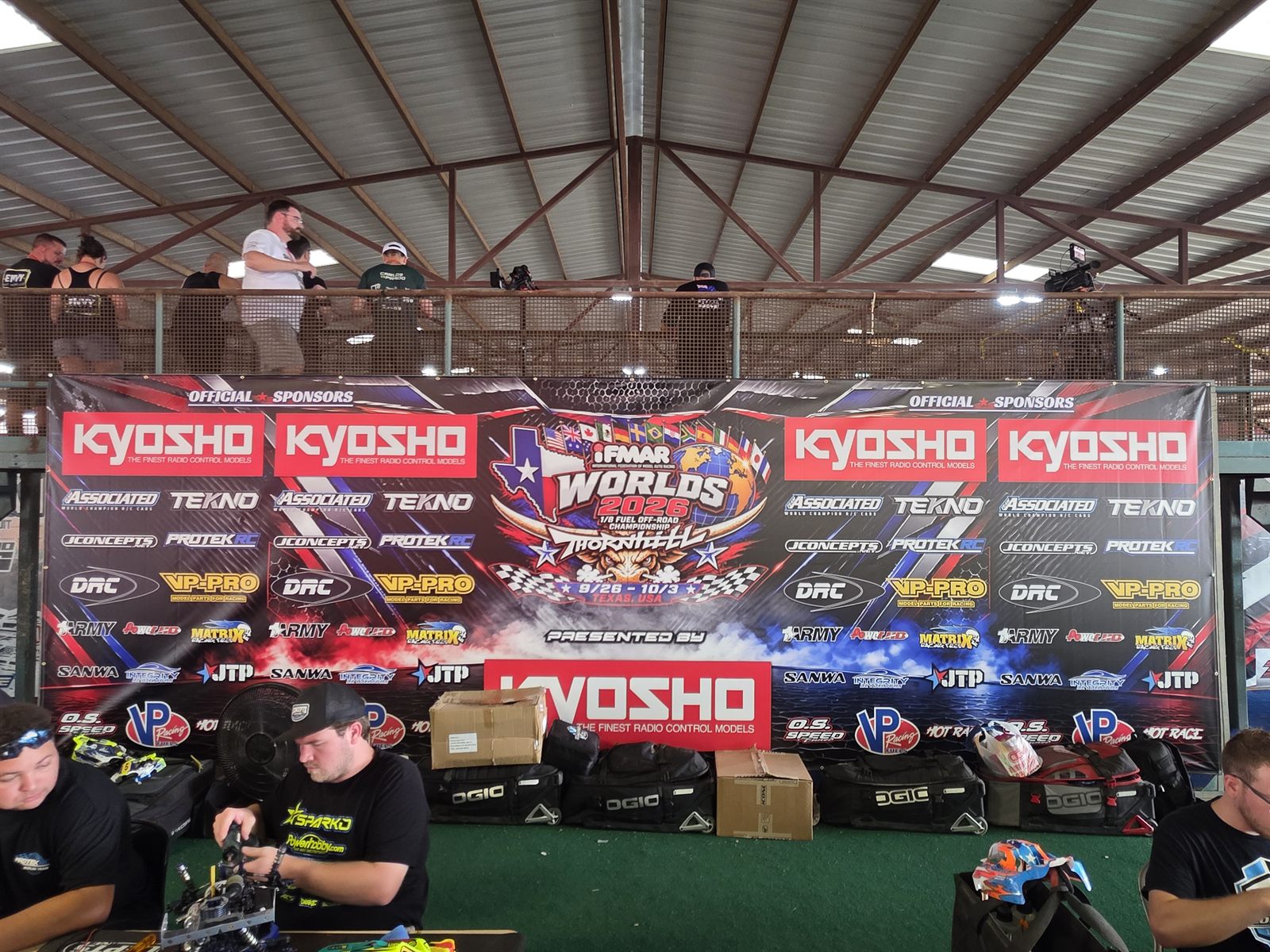 A large sponsor banner wall above the pit area at the 2026 IFMAR Worlds, featuring the Integrity RC Designs logo.